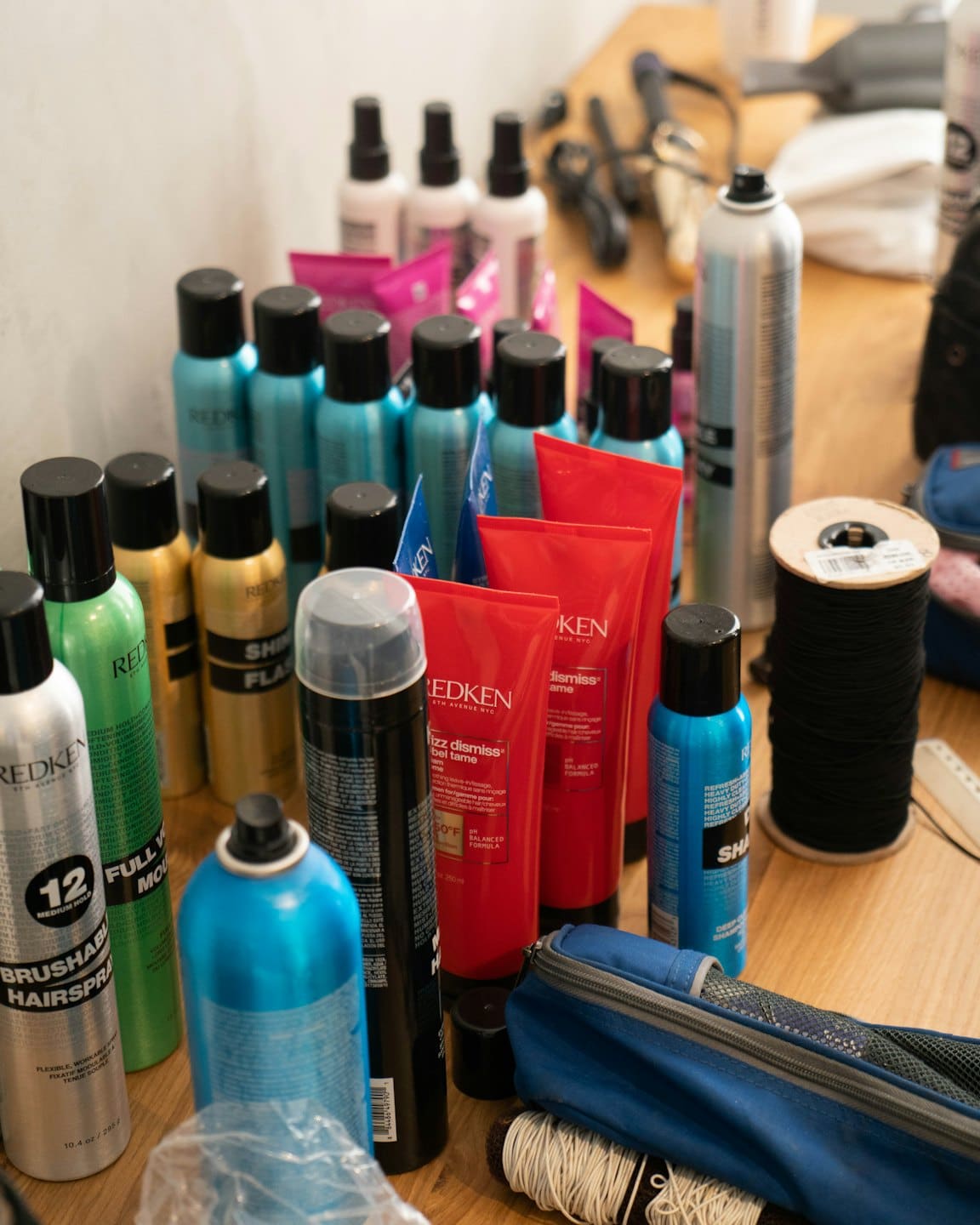 Various professional hair products arranged on a wooden surface.